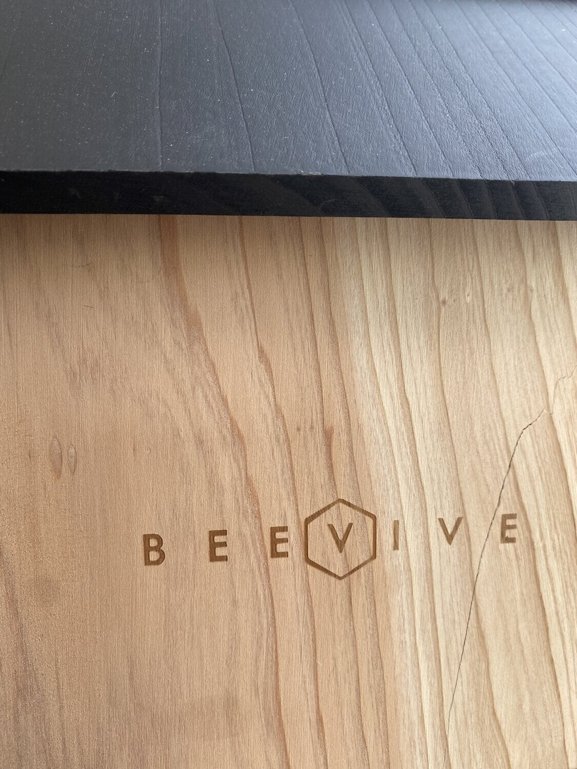side of non perfect bee hotel 2.0 showing scratch on wood next to beevive.com logo