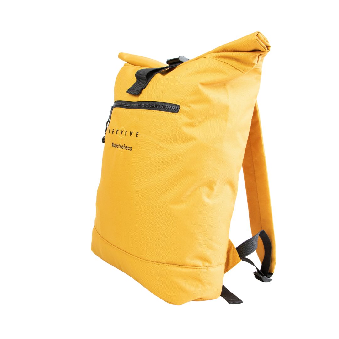 mustard coloured Beevive adventure recycled roll-top backpack stood upright on white background slight angle